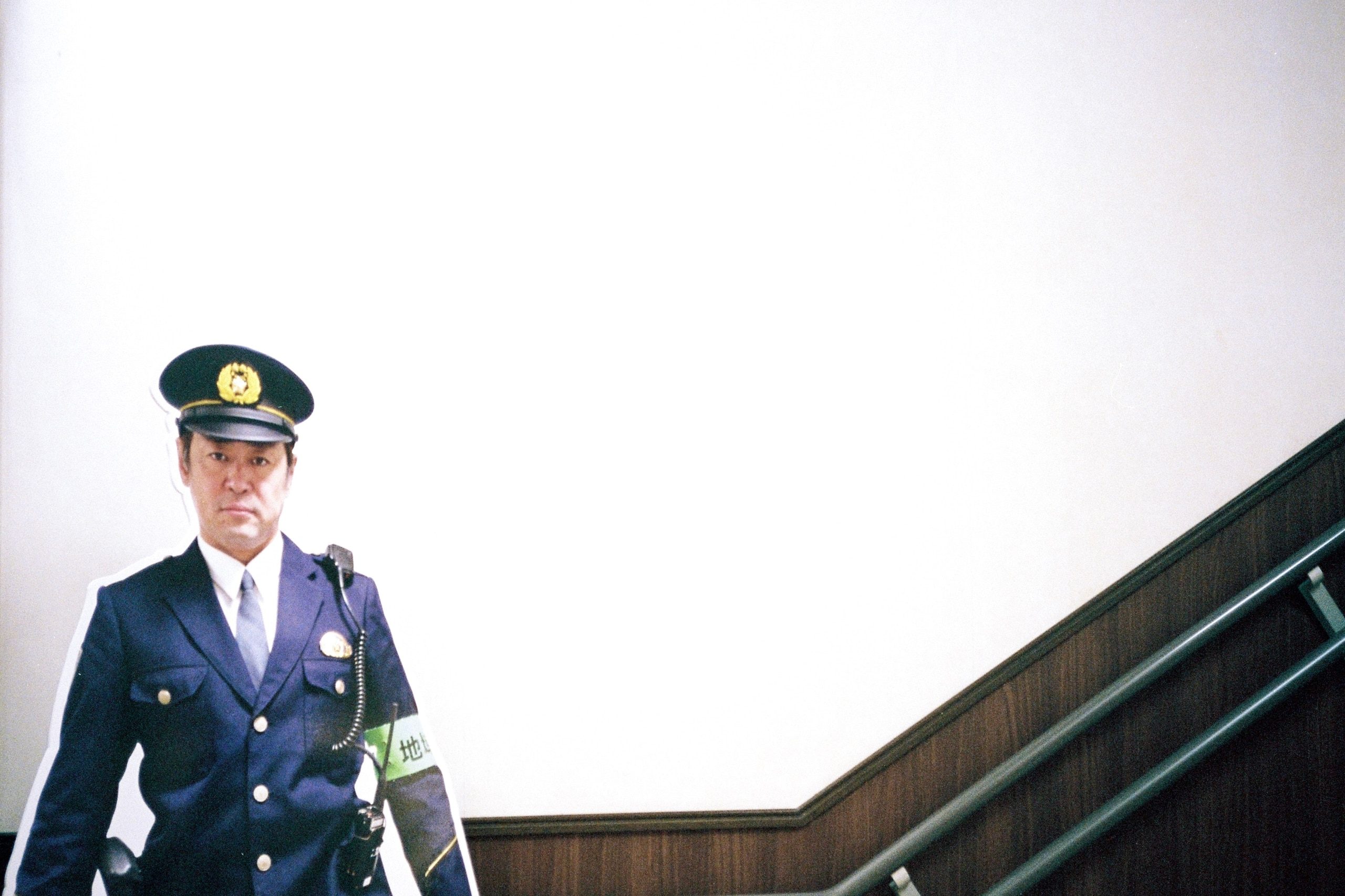 A cardboard cutout of a police officer stands beside a stairwell.